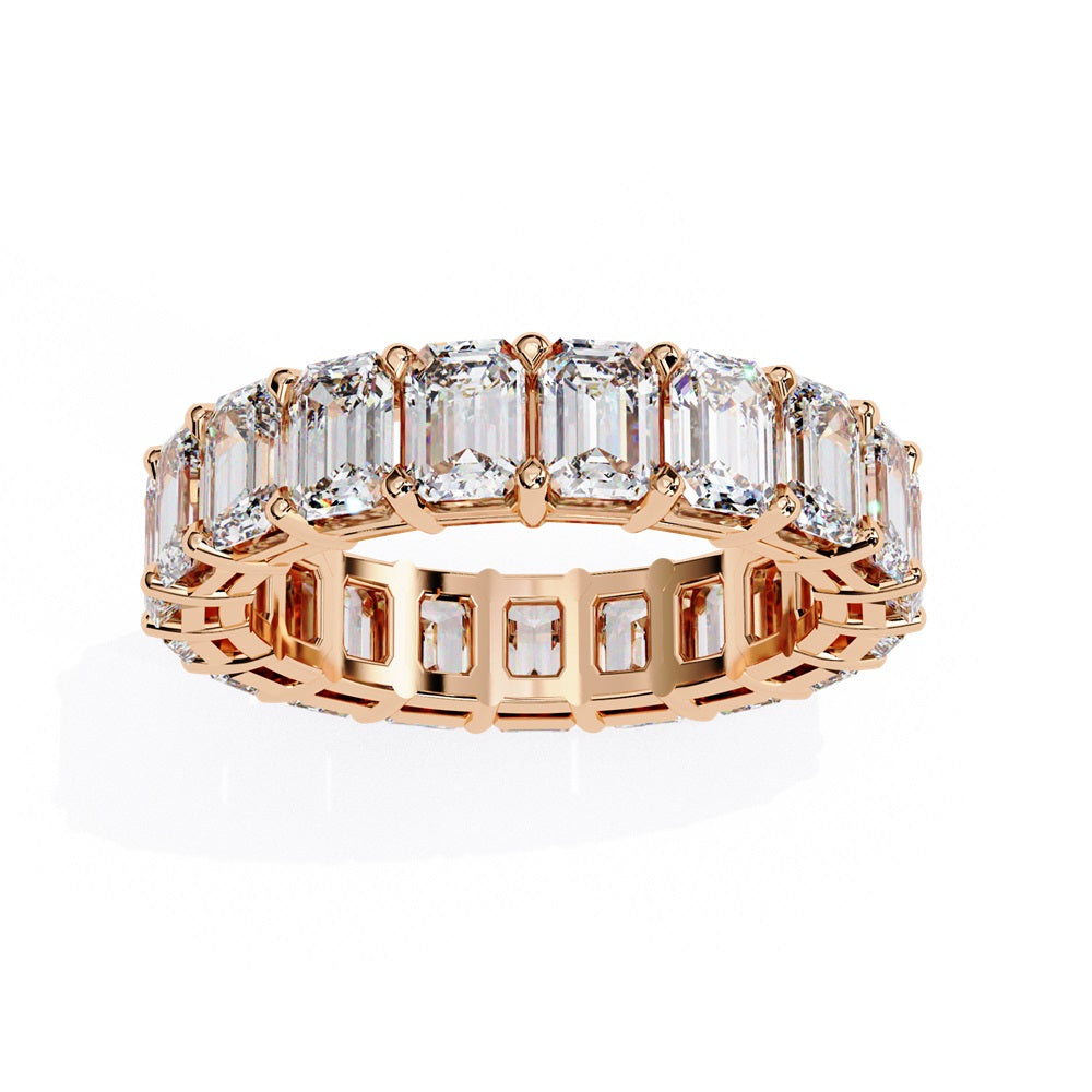 The Niraa Emerald Cut Diamond Eternity Band is a luxurious gold ring that features a continuous row of large prong-set emerald-cut diamonds, showcasing their brilliance and symmetry.