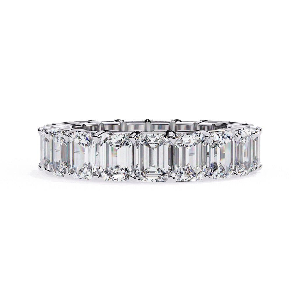 The Niraa Emerald Cut Diamond Eternity Band is a luxurious gold ring that features a continuous row of large prong-set emerald-cut diamonds, showcasing their brilliance and symmetry.