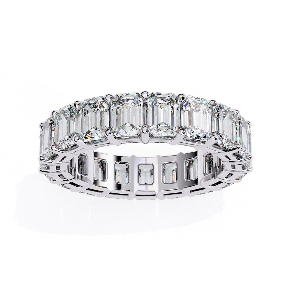 The Niraa Emerald Cut Diamond Eternity Band is a luxurious gold ring that features a continuous row of large prong-set emerald-cut diamonds, showcasing their brilliance and symmetry.
