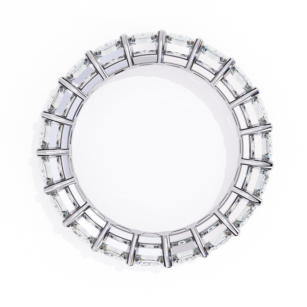 The Niraa Emerald Cut Diamond Eternity Band is a luxurious gold ring that features a continuous row of large prong-set emerald-cut diamonds, showcasing their brilliance and symmetry.