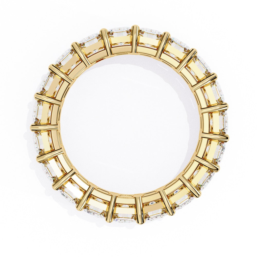 The Niraa Emerald Cut Diamond Eternity Band is a luxurious gold ring that features a continuous row of large prong-set emerald-cut diamonds, showcasing their brilliance and symmetry.