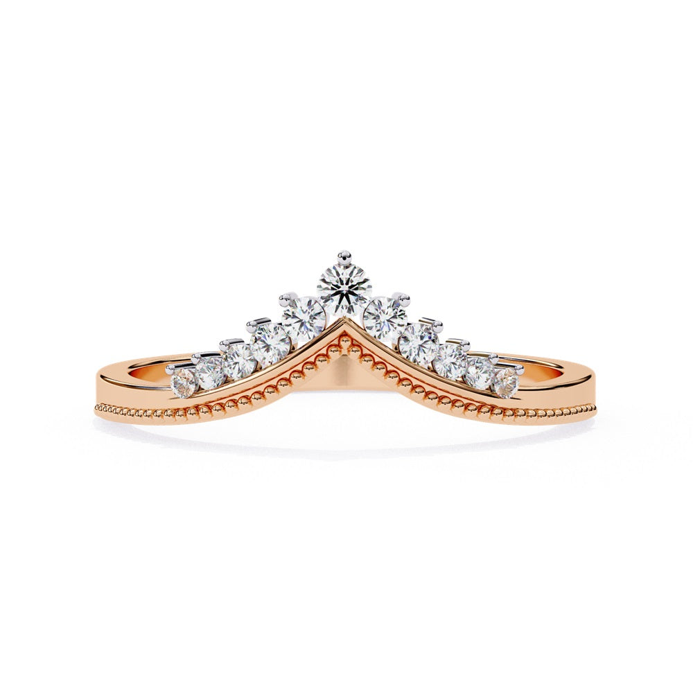 The Tiara Diamond Chevron Band by Niraa showcases a crown-like elegance with its gold band and row of sparkling diamonds, highlighted by a larger central diamond at the peak—an epitome of luxury.