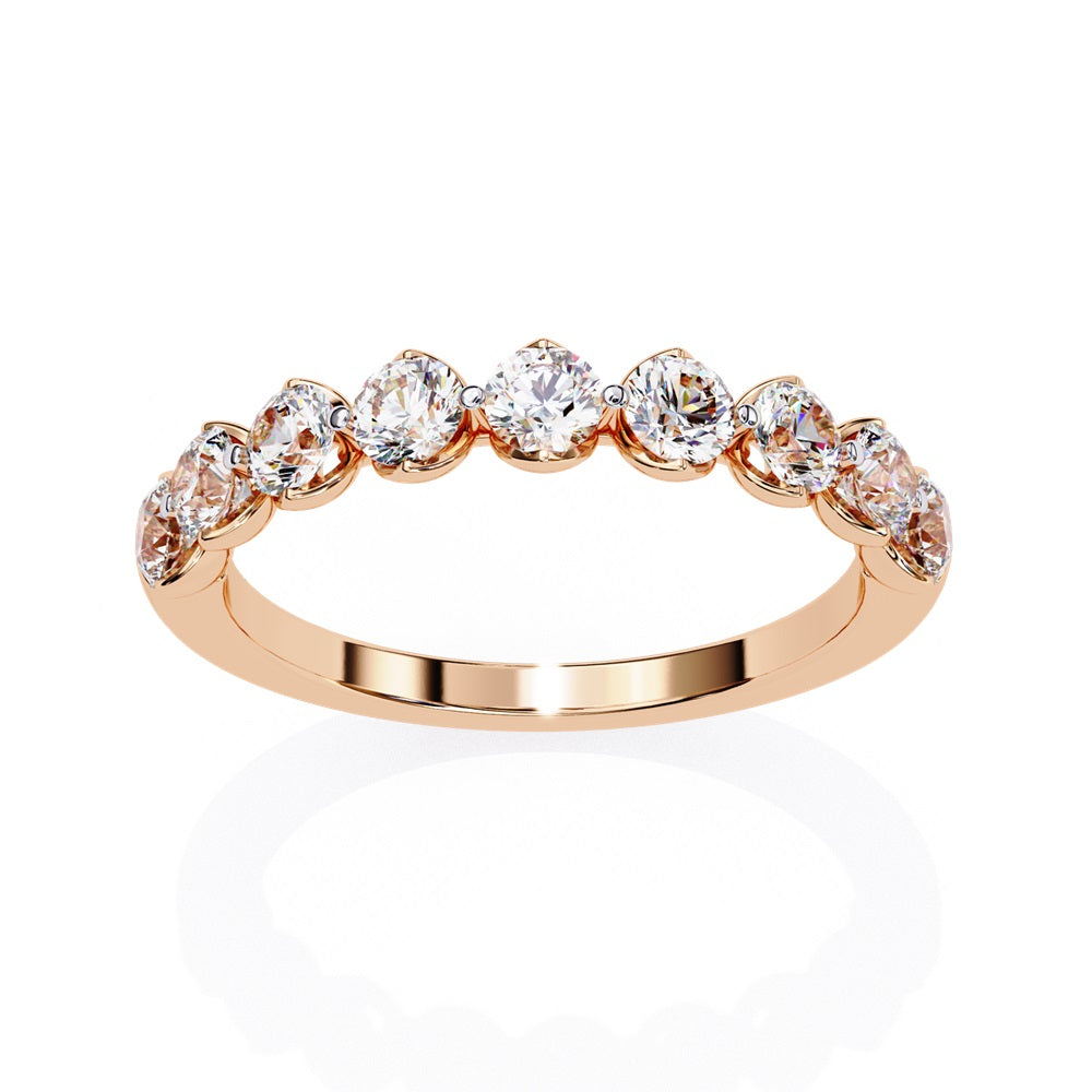 The Minimal Magic Diamond Band by Niraa is a luxury accessory featuring round, sparkling white diamonds, each set in its own bezel. The diamonds catch the light brilliantly, giving this gold ring an elegant and opulent allure.