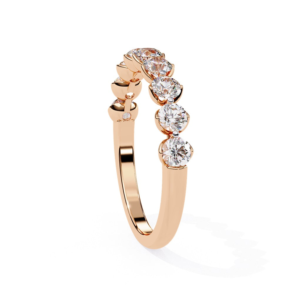 The Minimal Magic Diamond Band by Niraa is a luxury accessory featuring round, sparkling white diamonds, each set in its own bezel. The diamonds catch the light brilliantly, giving this gold ring an elegant and opulent allure.