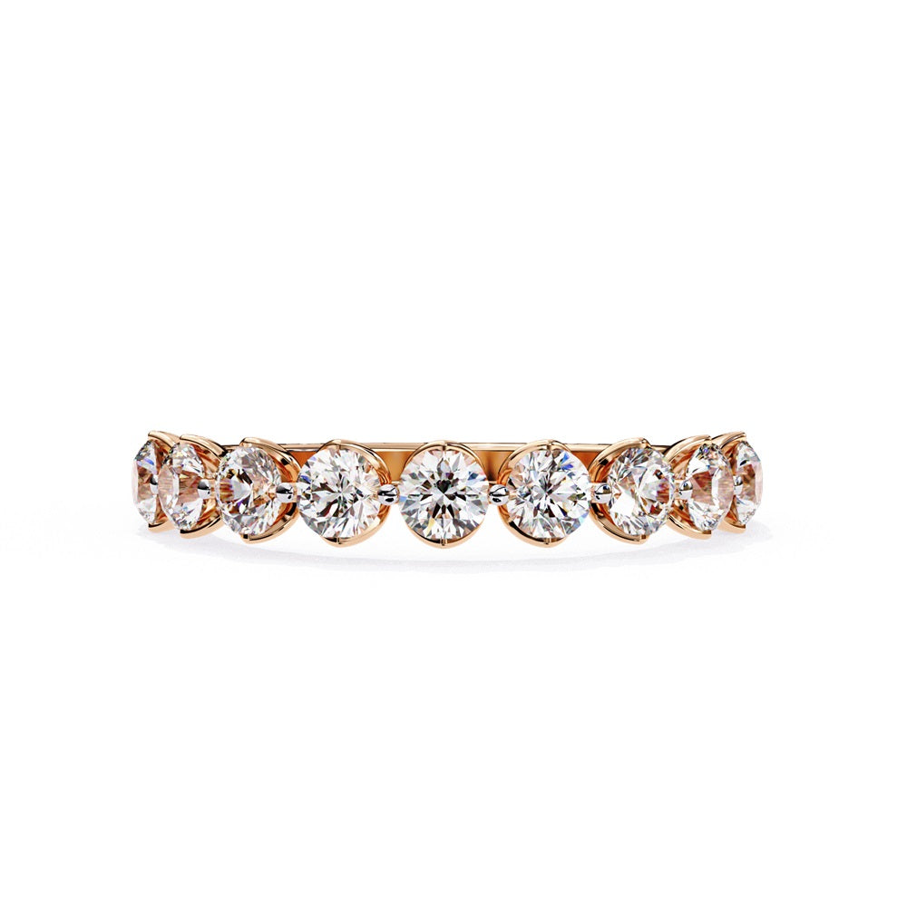 The Minimal Magic Diamond Band by Niraa is a luxury accessory featuring round, sparkling white diamonds, each set in its own bezel. The diamonds catch the light brilliantly, giving this gold ring an elegant and opulent allure.