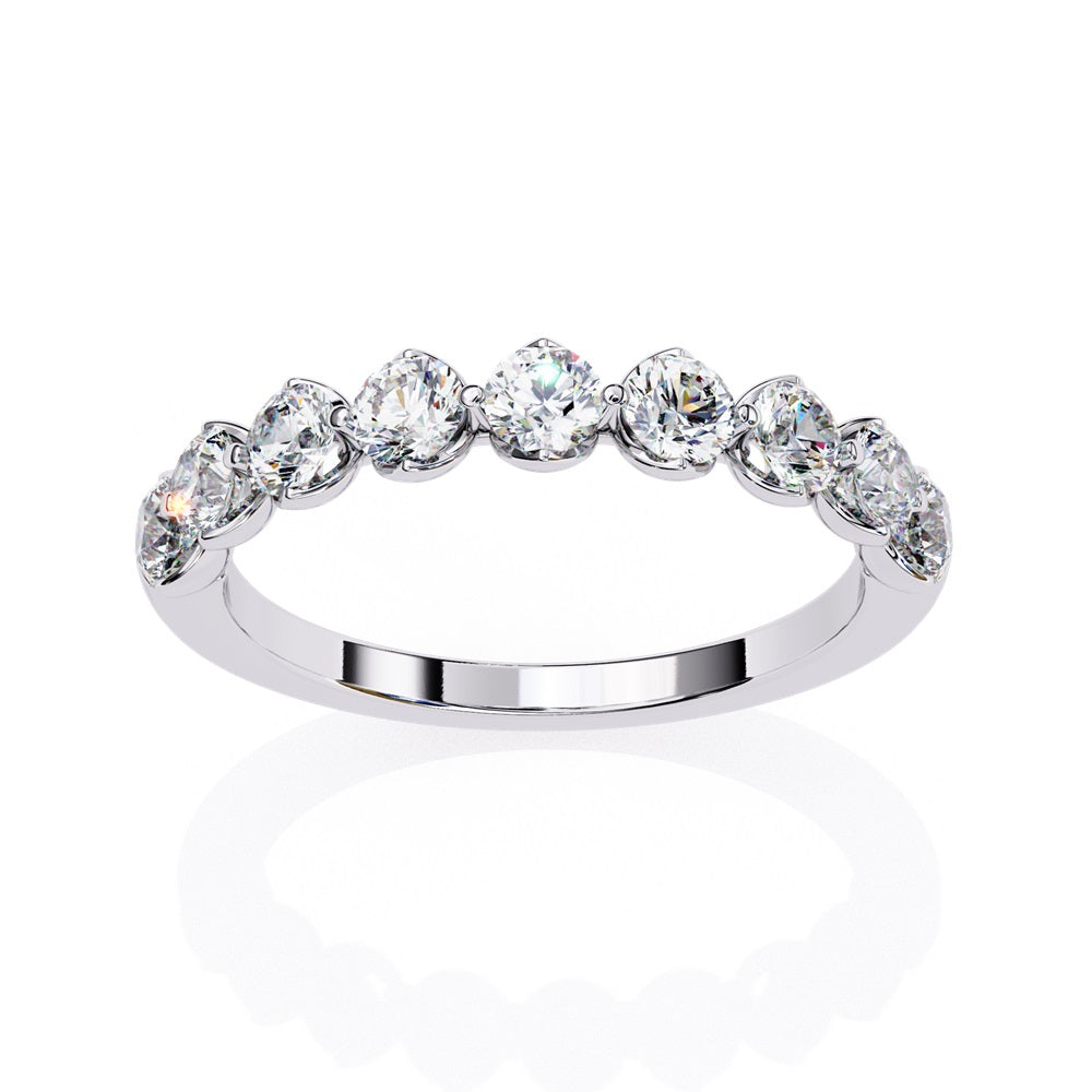 The Minimal Magic Diamond Band by Niraa is a luxury accessory featuring round, sparkling white diamonds, each set in its own bezel. The diamonds catch the light brilliantly, giving this gold ring an elegant and opulent allure.