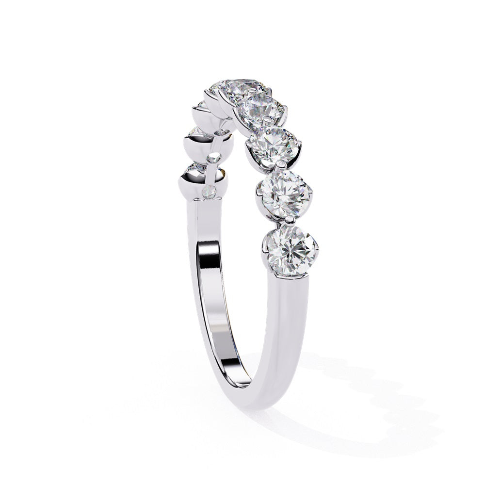 The Minimal Magic Diamond Band by Niraa is a luxury accessory featuring round, sparkling white diamonds, each set in its own bezel. The diamonds catch the light brilliantly, giving this gold ring an elegant and opulent allure.
