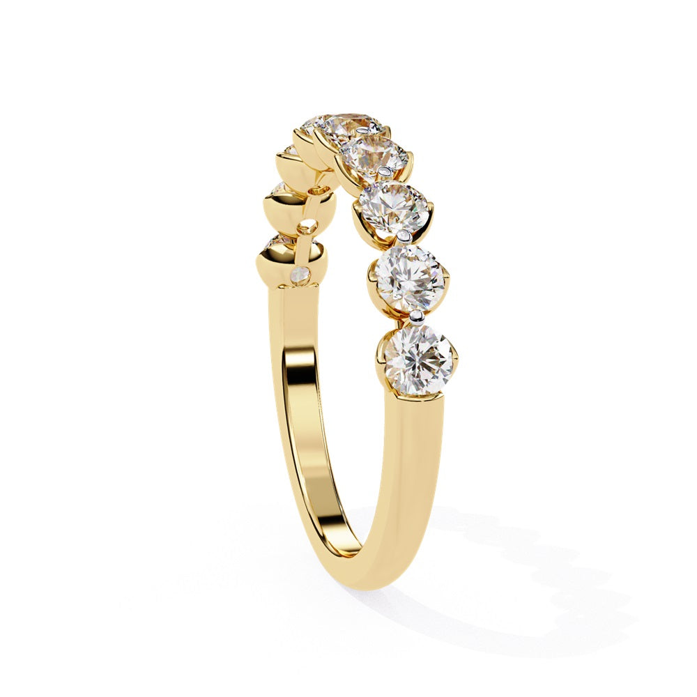 The Minimal Magic Diamond Band by Niraa is a luxury accessory featuring round, sparkling white diamonds, each set in its own bezel. The diamonds catch the light brilliantly, giving this gold ring an elegant and opulent allure.