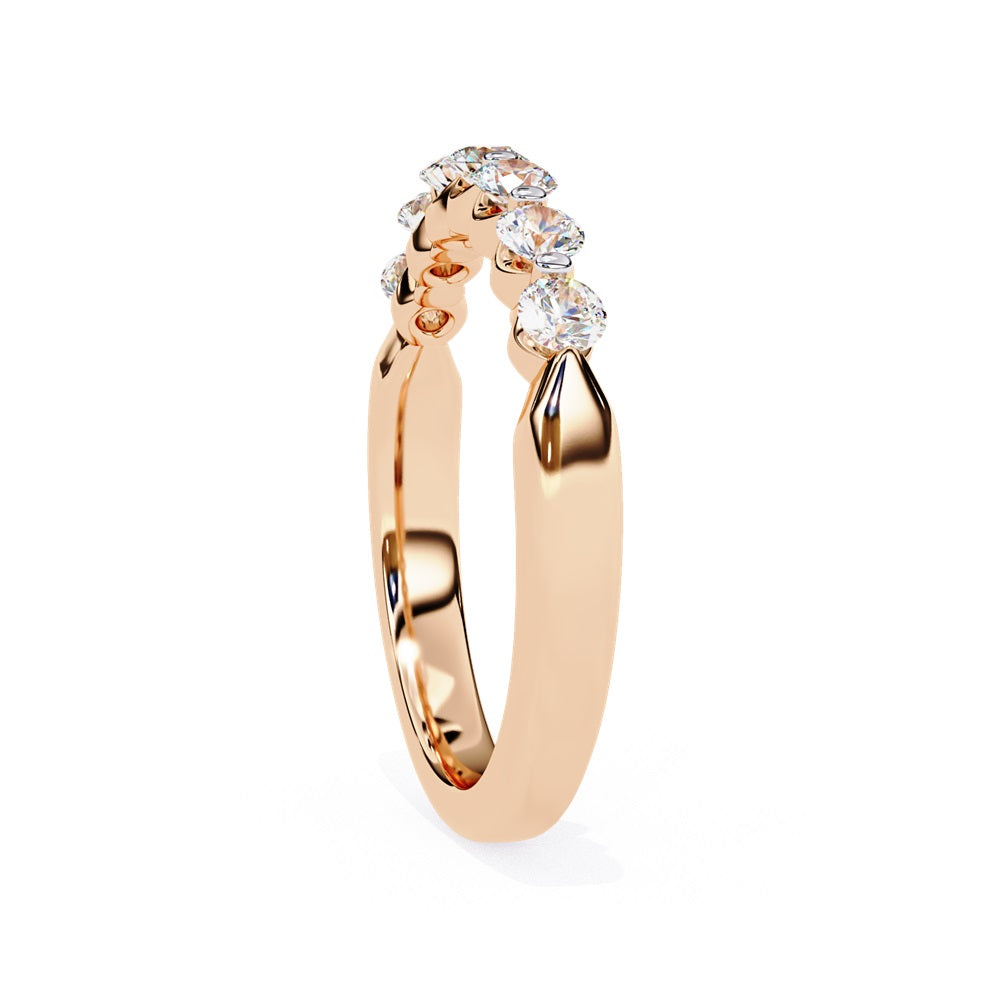 The Niraa Seven Star Diamond Band is a luxurious gold ring with seven round, evenly spaced, sparkling diamonds, offering elegance and sophistication. The exquisite accessory is beautifully showcased on a plain white background.