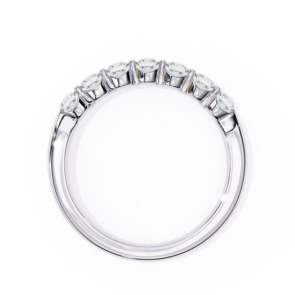 The Niraa Seven Star Diamond Band is a luxurious gold ring with seven round, evenly spaced, sparkling diamonds, offering elegance and sophistication. The exquisite accessory is beautifully showcased on a plain white background.