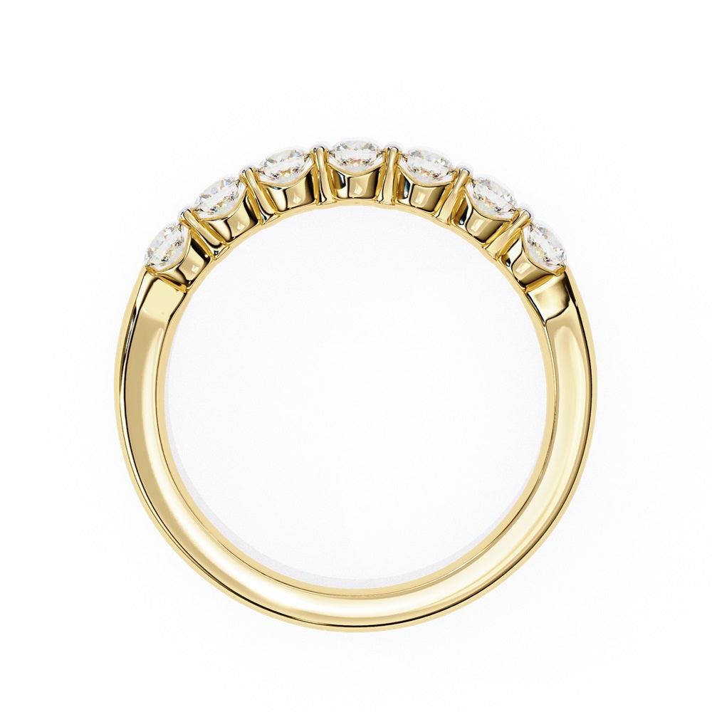 The Niraa Seven Star Diamond Band is a luxurious gold ring with seven round, evenly spaced, sparkling diamonds, offering elegance and sophistication. The exquisite accessory is beautifully showcased on a plain white background.
