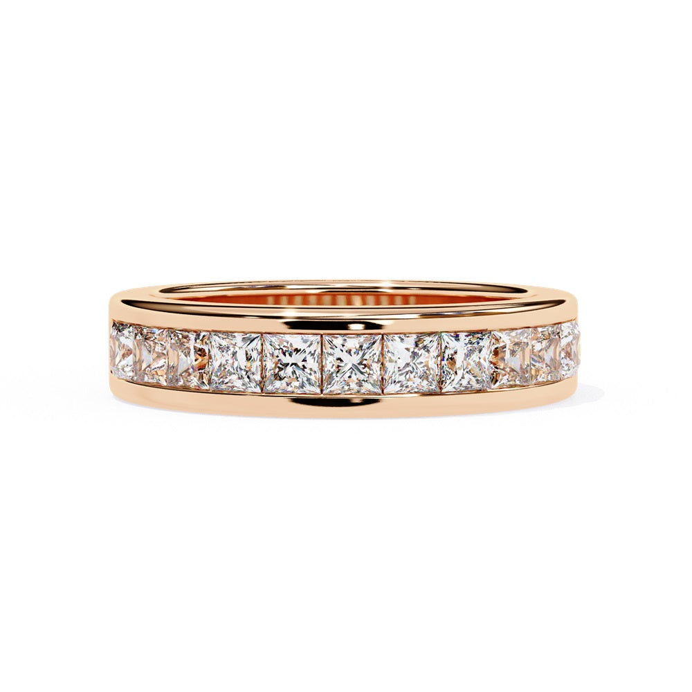 The Niraa Princess Channel Diamond Band is a stunning gold piece featuring square-cut, clear gemstones in a channel setting, elegantly viewed from the side against a plain white background.
