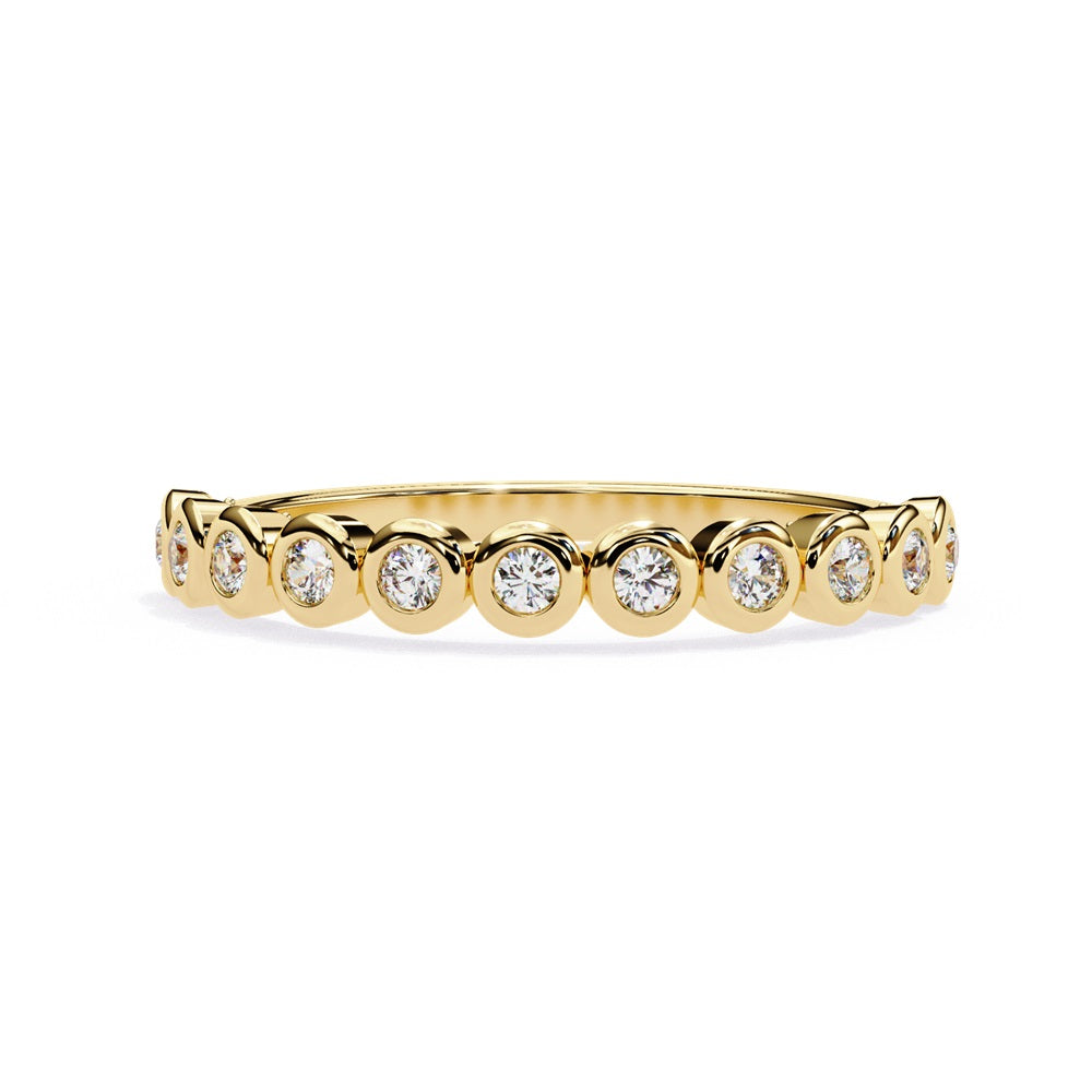 The Basel Diamond Band by Niraa is a luxurious gold ring featuring small, round diamonds set in individual bezels for a continuous sparkling effect.