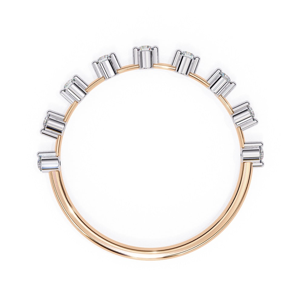 The Sunrise Diamond Band by Niraa is a luxurious gold ring featuring an elegant alternating pattern of round and baguette-cut diamonds set in a row, beautifully showcasing the sparkling gemstones against its smooth surface.