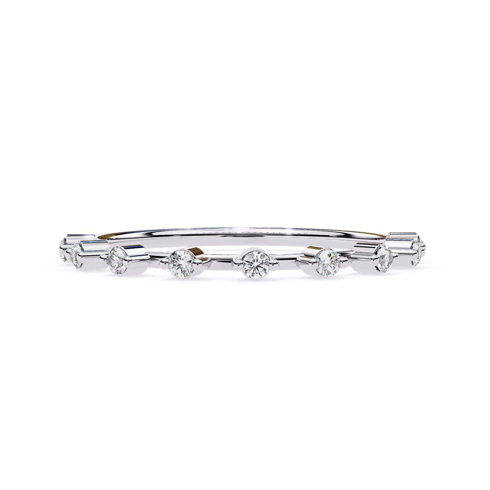 The Sunrise Diamond Band by Niraa is a luxurious gold ring featuring an elegant alternating pattern of round and baguette-cut diamonds set in a row, beautifully showcasing the sparkling gemstones against its smooth surface.