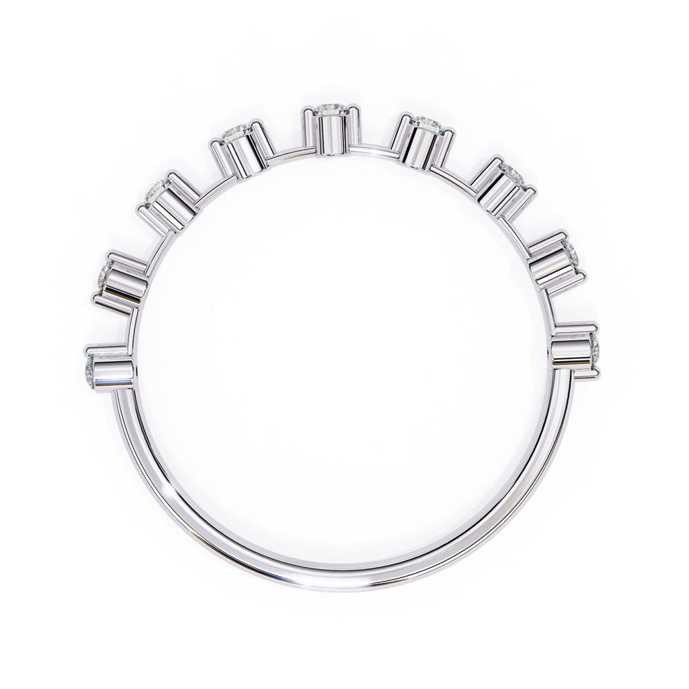The Sunrise Diamond Band by Niraa is a luxurious gold ring featuring an elegant alternating pattern of round and baguette-cut diamonds set in a row, beautifully showcasing the sparkling gemstones against its smooth surface.