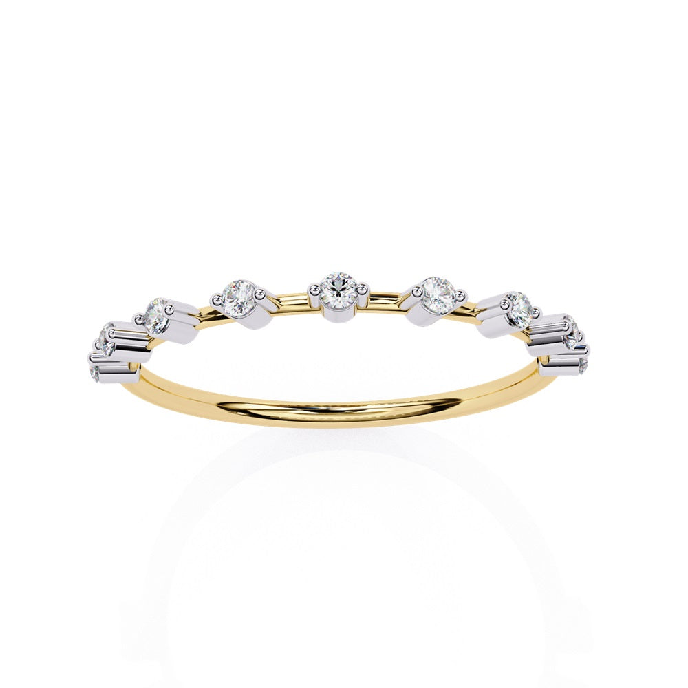 The Sunrise Diamond Band by Niraa is a luxurious gold ring featuring an elegant alternating pattern of round and baguette-cut diamonds set in a row, beautifully showcasing the sparkling gemstones against its smooth surface.