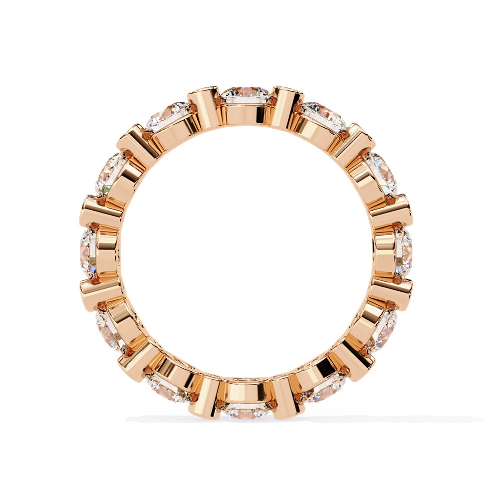 The Niraa Dazzling Diamond Eternity Band, adorned with alternating large and small round diamonds encircling the gold band, embodies luxury through its symmetrical design, showcasing brilliance and elegance in perfect harmony.