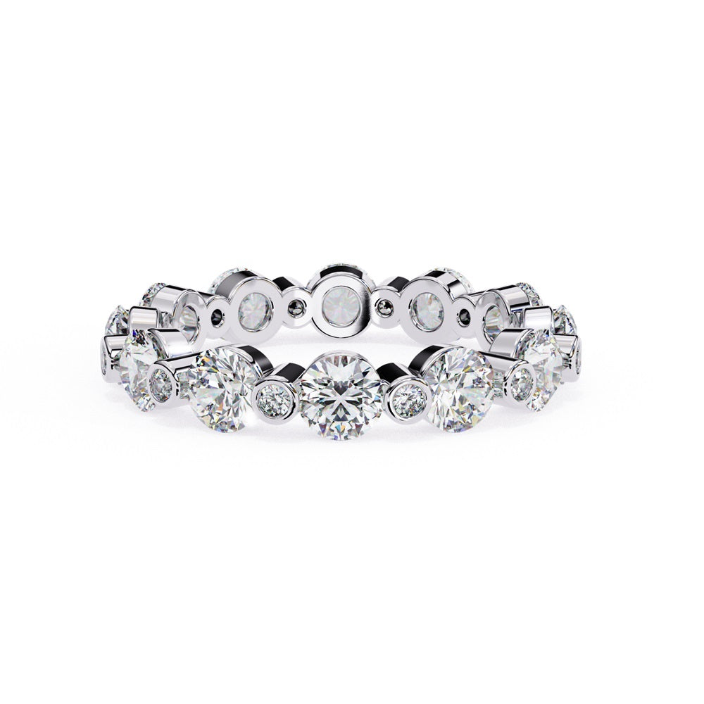 The Niraa Dazzling Diamond Eternity Band, adorned with alternating large and small round diamonds encircling the gold band, embodies luxury through its symmetrical design, showcasing brilliance and elegance in perfect harmony.