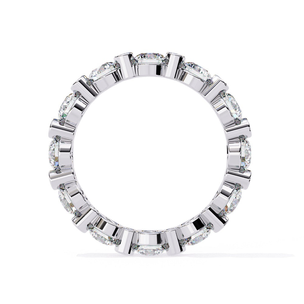 The Niraa Dazzling Diamond Eternity Band, adorned with alternating large and small round diamonds encircling the gold band, embodies luxury through its symmetrical design, showcasing brilliance and elegance in perfect harmony.