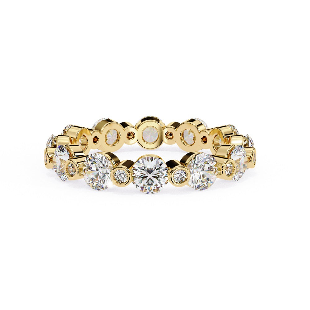 The Niraa Dazzling Diamond Eternity Band, adorned with alternating large and small round diamonds encircling the gold band, embodies luxury through its symmetrical design, showcasing brilliance and elegance in perfect harmony.