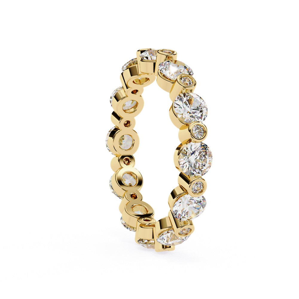 The Niraa Dazzling Diamond Eternity Band, adorned with alternating large and small round diamonds encircling the gold band, embodies luxury through its symmetrical design, showcasing brilliance and elegance in perfect harmony.