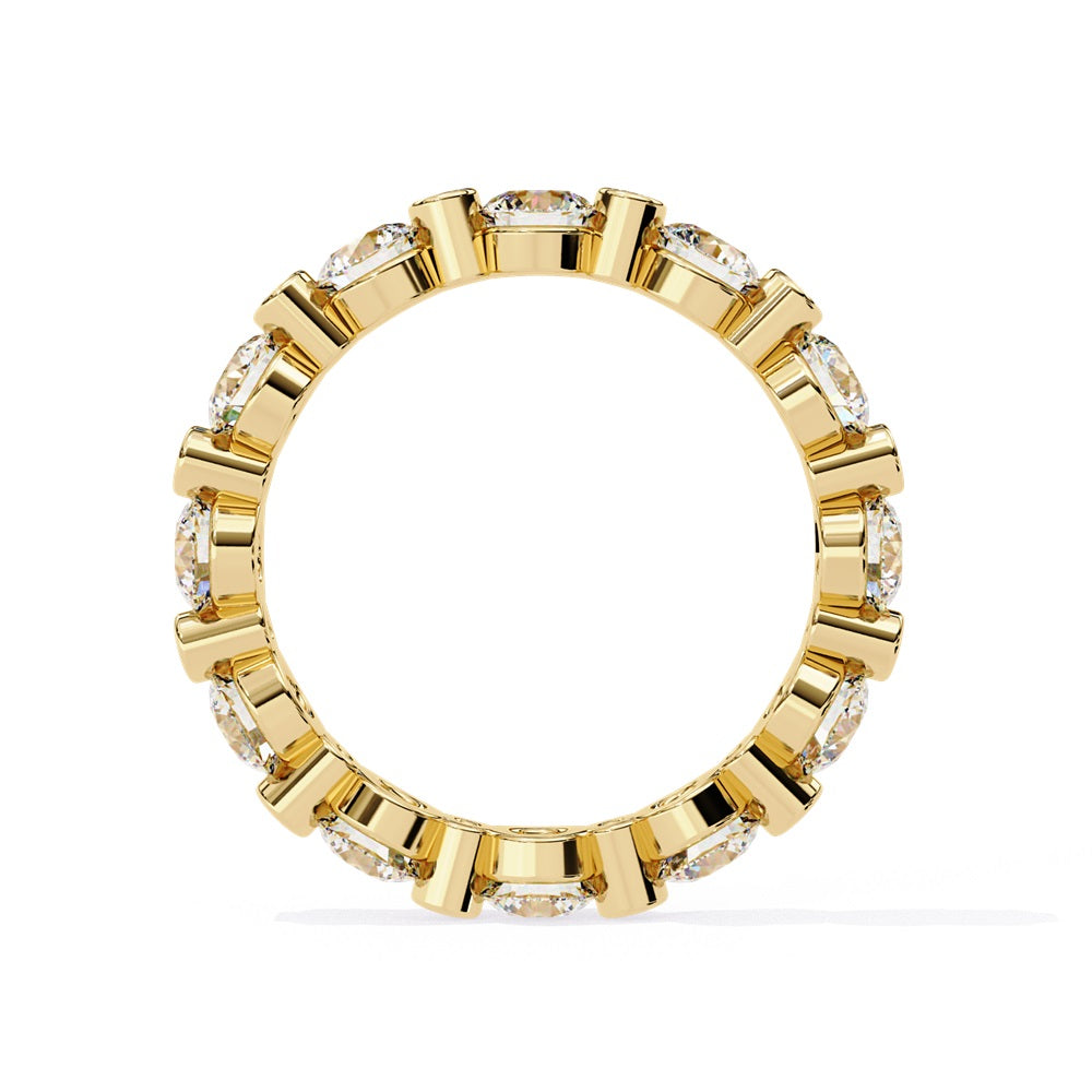 The Niraa Dazzling Diamond Eternity Band, adorned with alternating large and small round diamonds encircling the gold band, embodies luxury through its symmetrical design, showcasing brilliance and elegance in perfect harmony.