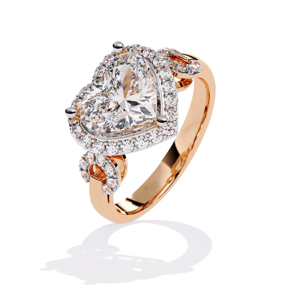 A heart-shaped diamond ring in gold, featuring a solitaire design with a halo of smaller diamonds surrounding it.