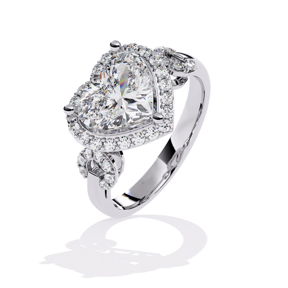 A heart-shaped diamond ring in gold, featuring a solitaire design with a halo of smaller diamonds surrounding it.