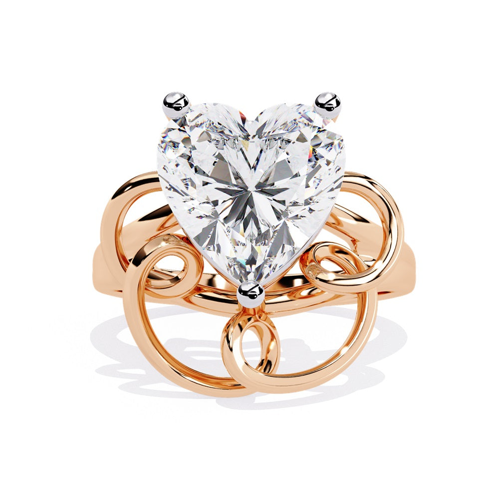 A heart-shaped diamond ring in gold, featuring a solitaire design featuring an intricate pattern below the heart.