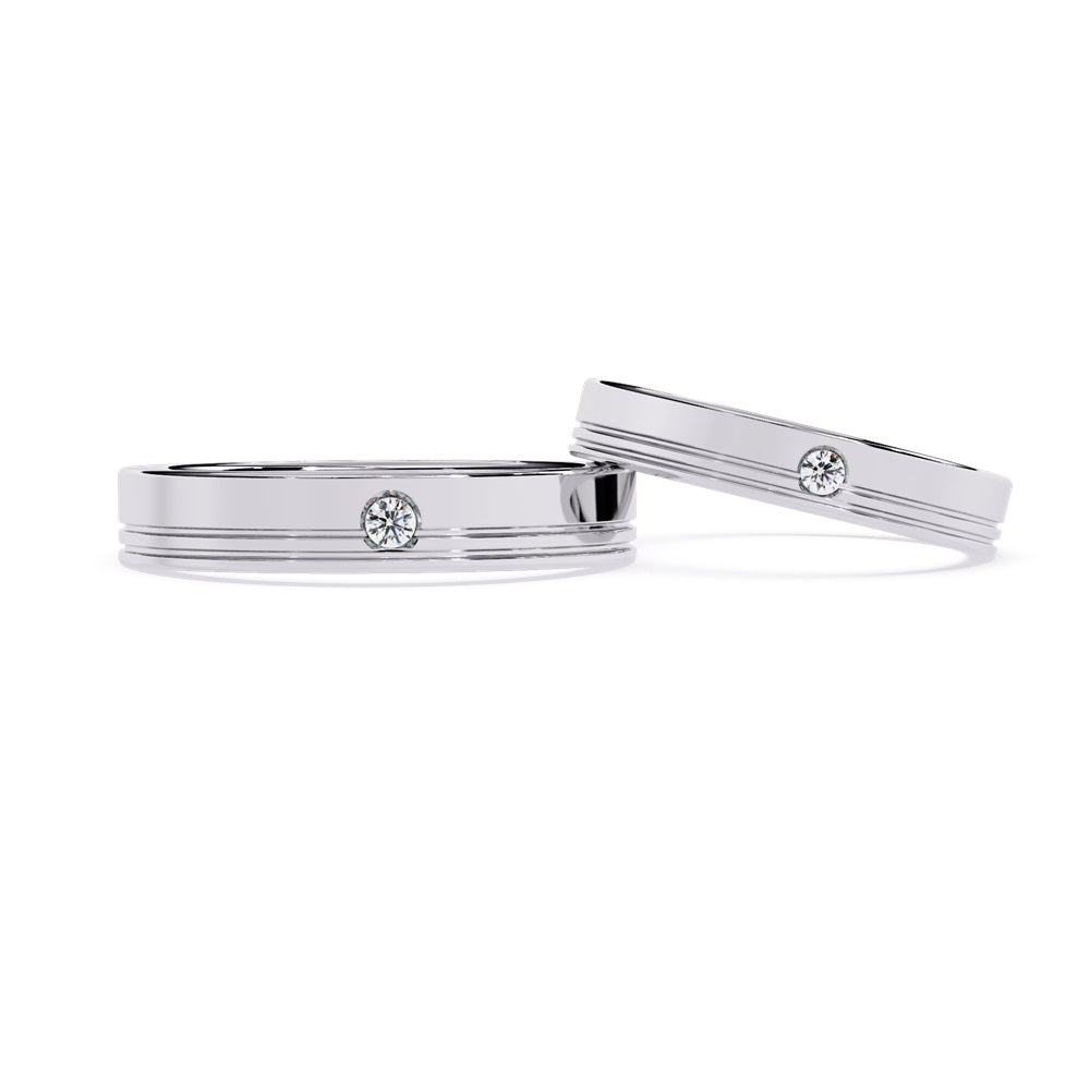Two elegant gold wedding bands adorned with diamonds, symbolizing love and commitment for a couple.