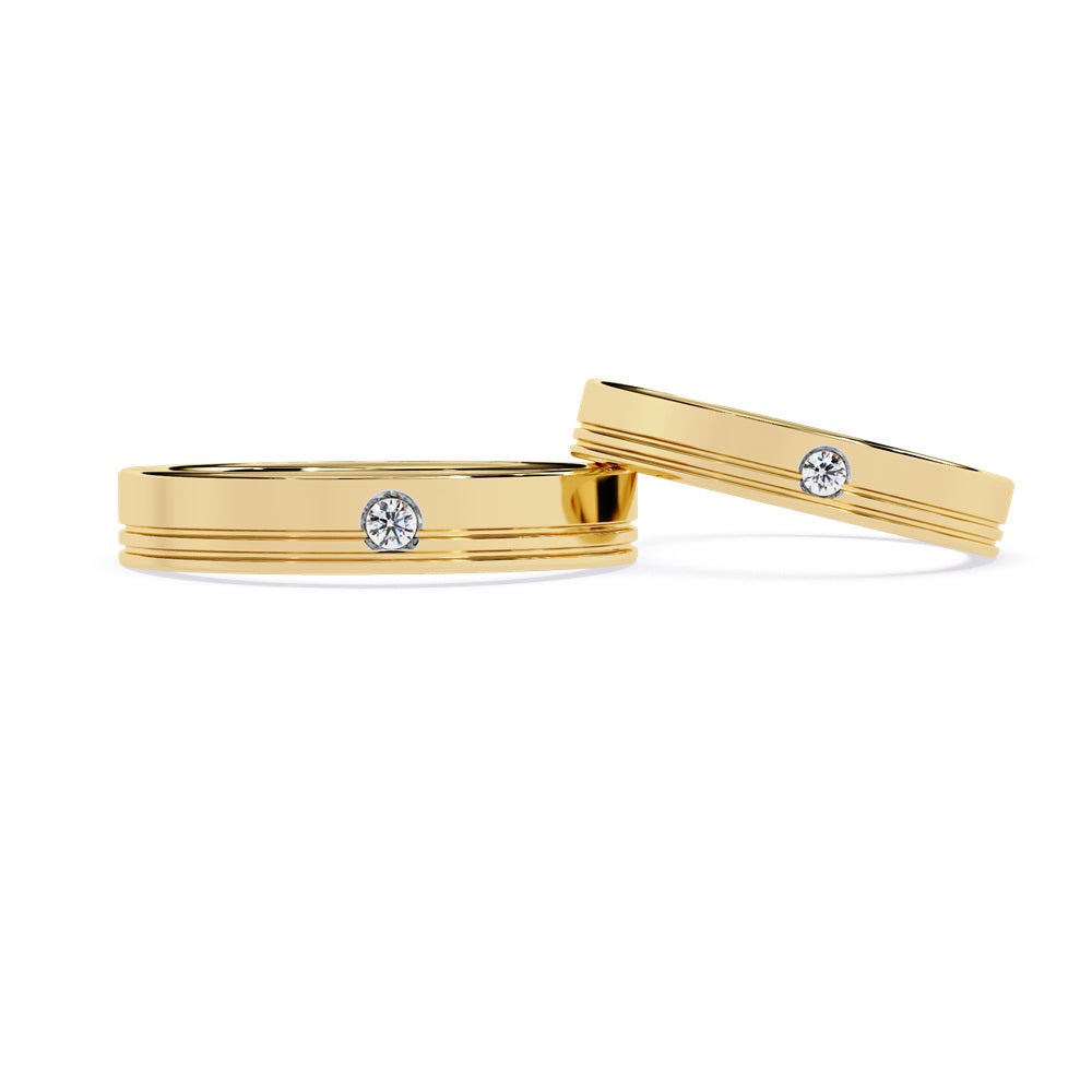 Two elegant gold wedding bands adorned with diamonds, symbolizing love and commitment for a couple.