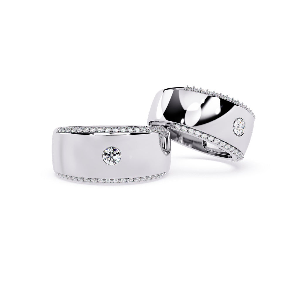 A pair of gold wedding bands featuring sparkling diamonds, representing a couple's eternal bond