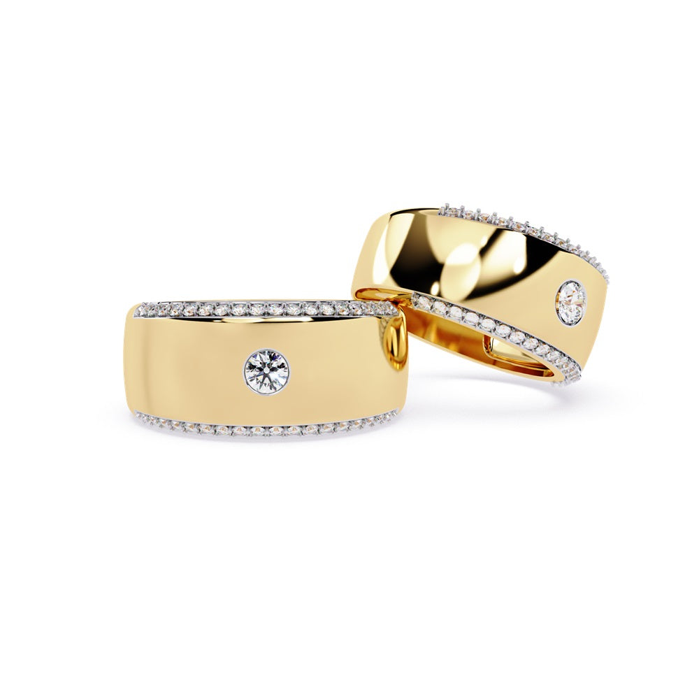 A pair of gold wedding bands featuring sparkling diamonds, representing a couple's eternal bond