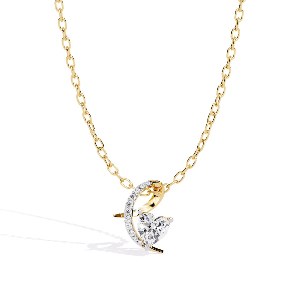 The Radiance Heart Shape Diamond Solitaire Pendant by Niraa is a gold necklace with a heart-shaped crystal pendant, complemented by a crescent adorned with smaller crystals. Its delicately linked chain ensures the centerpiece remains elegant and captivating.