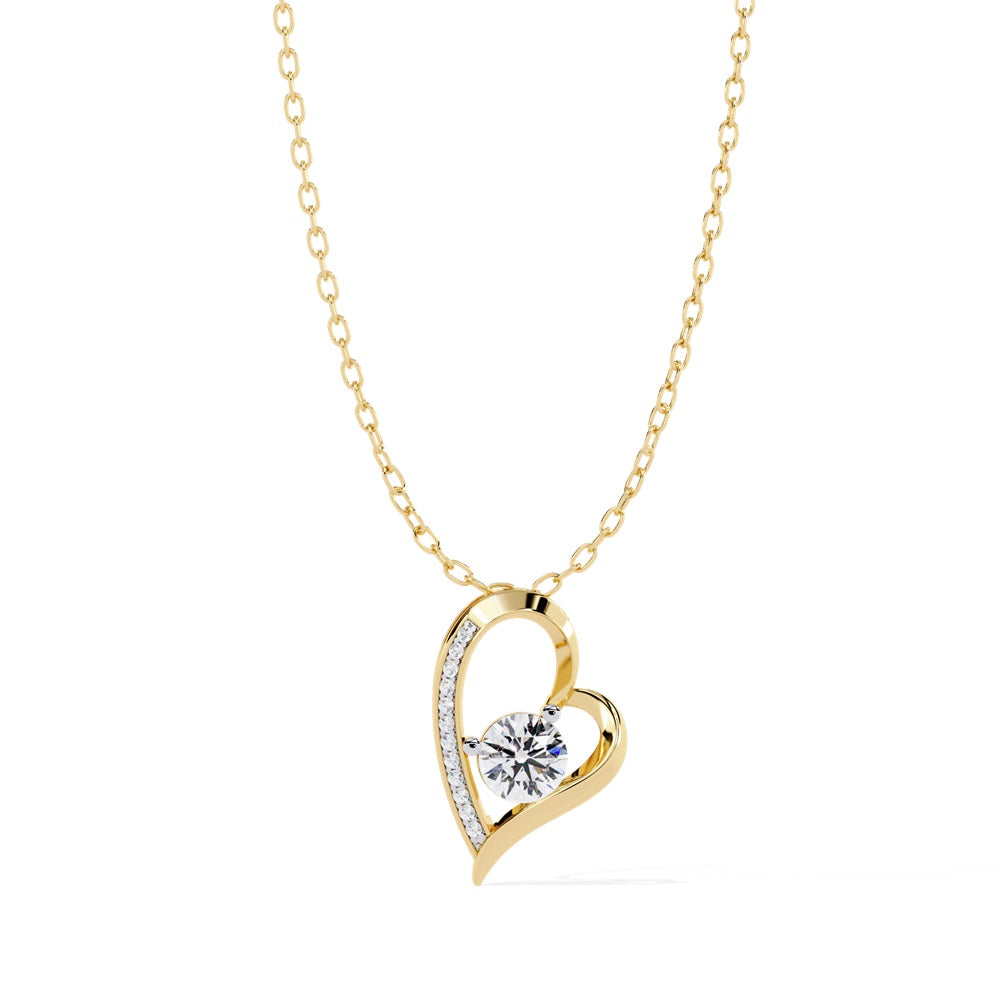 The Niraa Divine Diamond Solitaire Pendant features a graceful gold necklace with a heart-shaped pendant. A central sparkling diamond is flanked by smaller diamonds on one side, making it a timeless piece that embodies subtle luxury for any occasion.