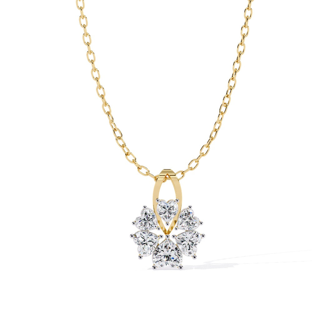 The Niraa Bloom Heart Shape Diamond Solitaire Pendant is a gold chain necklace featuring six heart-shaped diamonds forming a floral blossom around a central stone, set in a symmetrical gold frame, capturing timeless beauty and sophistication.
