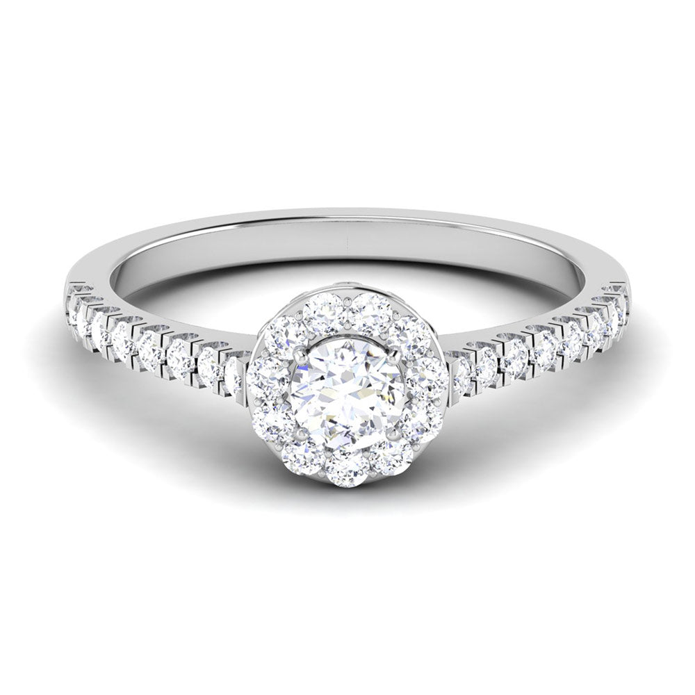 The Roxanne Diamond Solitaire Ring by Niraa features a central round diamond encircled by a halo of smaller diamonds on a silver band, adorned with additional diamonds for an elegant and sophisticated sparkle.