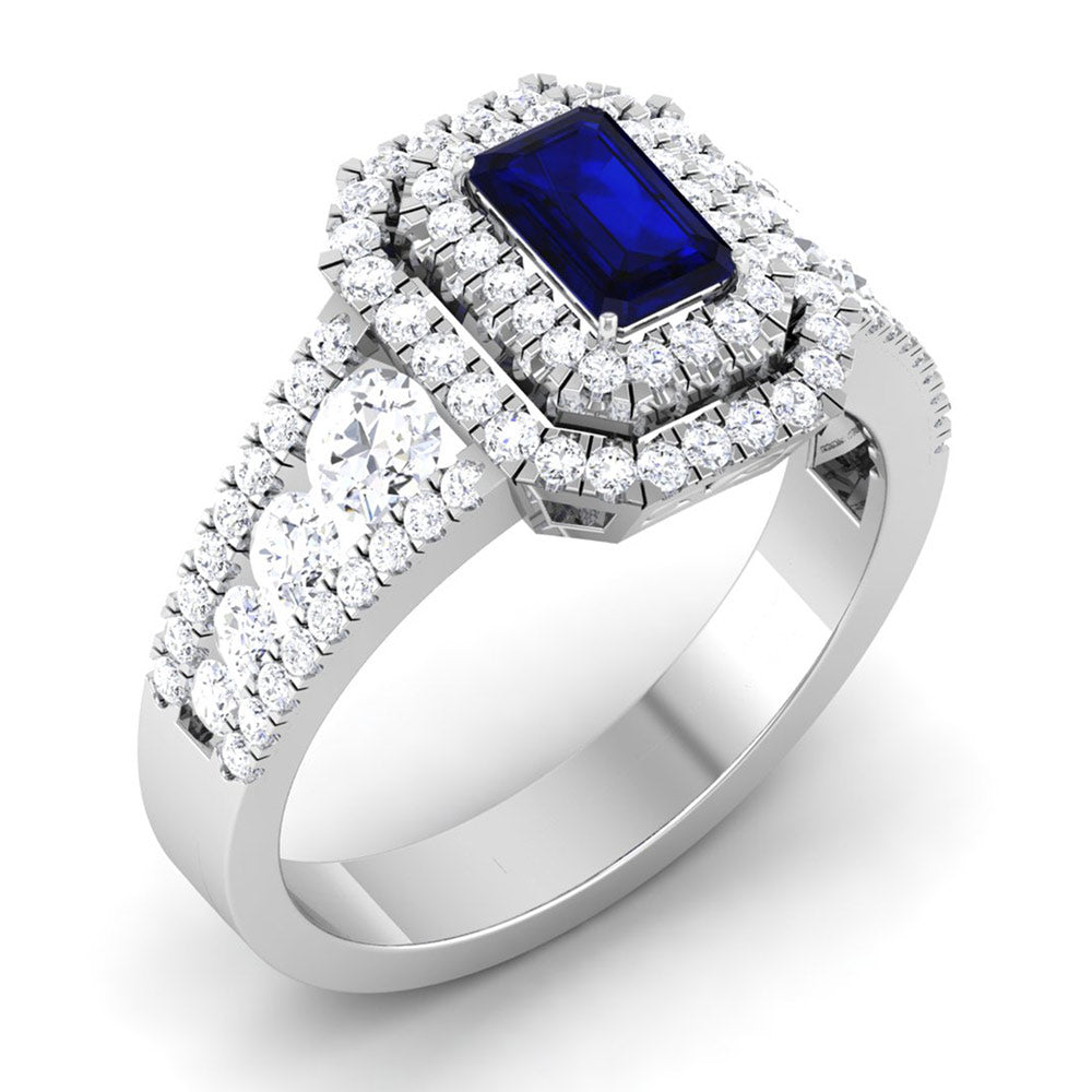 The Primrose Diamond Ladies Ring by Niraa is a luxurious silver ring featuring a prominent rectangular blue gemstone, framed by two rows of sparkling white diamonds. The diamond-encrusted band amplifies its elegance, epitomizing opulence and style.