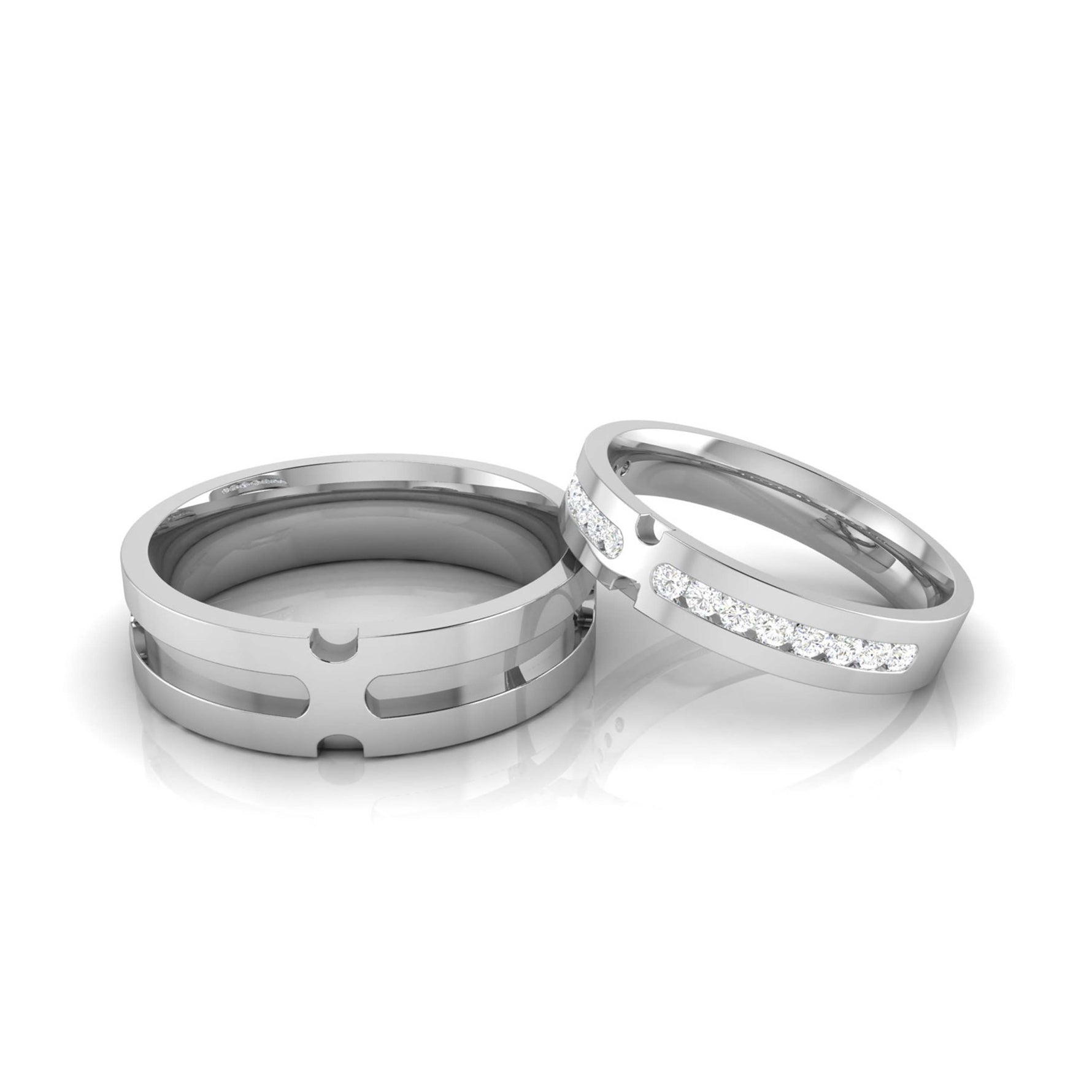 The Zariyah Diamond Ladies Ring by Niraa rests elegantly on a reflective surface, its slim band adorned with small embedded diamonds. Contrasting with the wider grooved silver ring beside it, both showcase a polished finish, embodying elegance and timeless beauty.