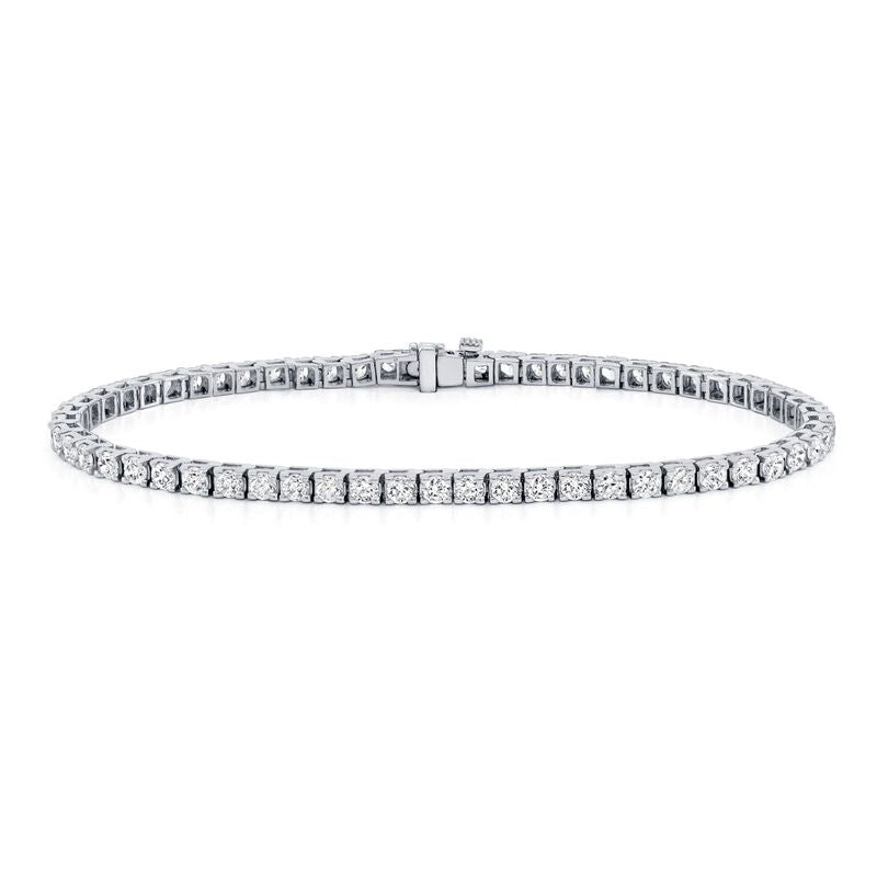 A delicate white gold tennis bracelet set with a continuous row of round, sparkling diamonds, displayed in a circular shape on a white background.