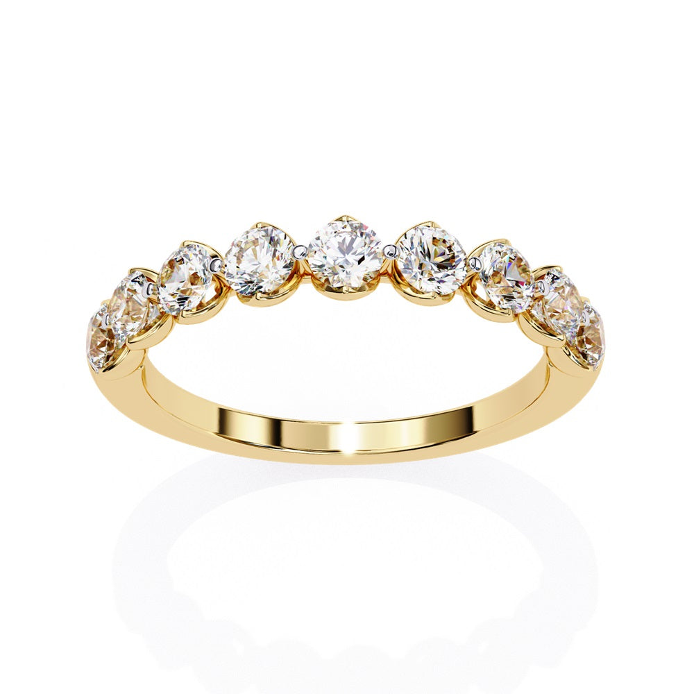 The Minimal Magic Diamond Band by Niraa is a luxury accessory featuring round, sparkling white diamonds, each set in its own bezel. The diamonds catch the light brilliantly, giving this gold ring an elegant and opulent allure.