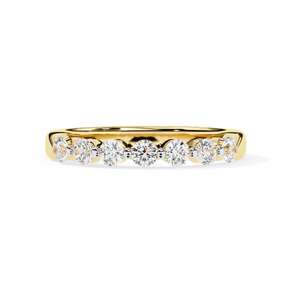 The Niraa Seven Star Diamond Band is a luxurious gold ring with seven round, evenly spaced, sparkling diamonds, offering elegance and sophistication. The exquisite accessory is beautifully showcased on a plain white background.